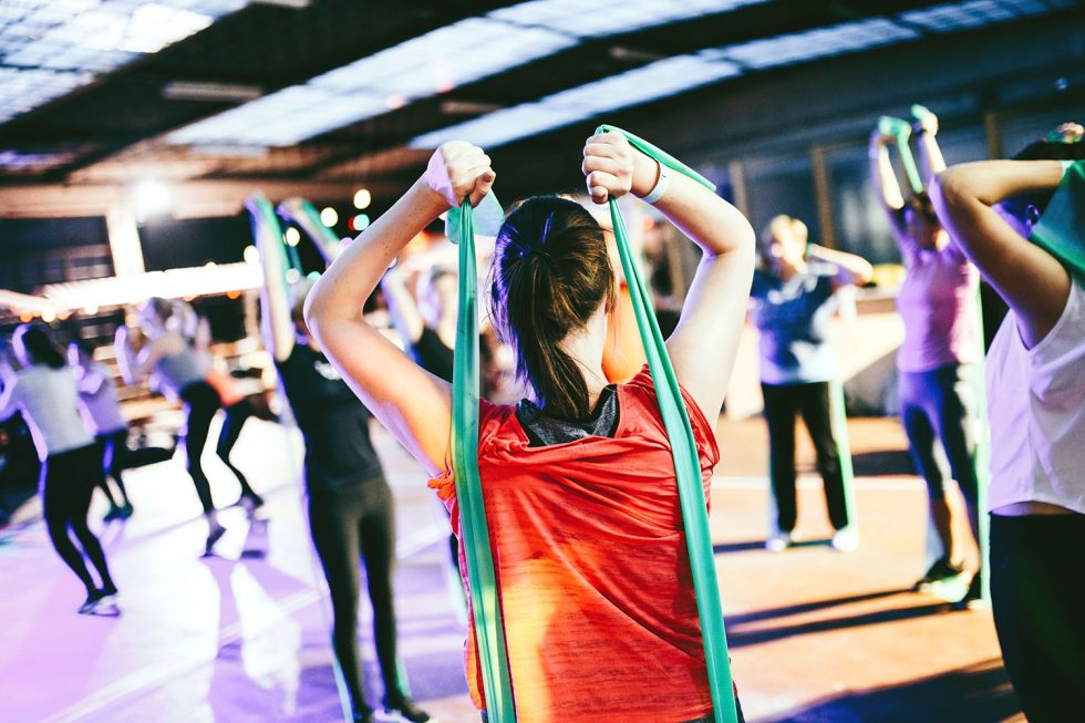  esta mulher exercitando com bandas pode não competir, mas há benefícios para a terapia de massagem esportiva para ela.